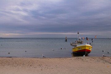 Naklejka premium fishing boat standing on the sandy shores of the steel sea