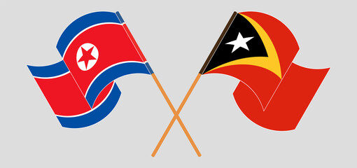 Crossed and waving flags of North Korea and East Timor