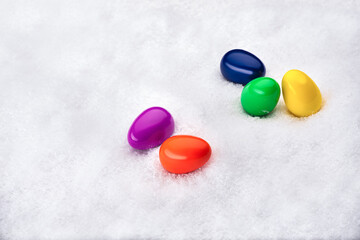 Colorful toy eggs on artificial snow