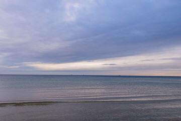 Fototapeta na wymiar beautiful calm sea waving in the early morning on a golden sandy beach