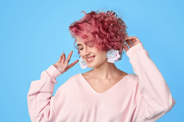 Young girl with pink hair with carnation flower in earrings
