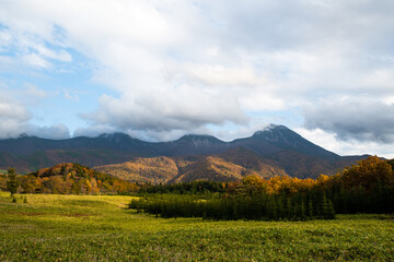 秋の知床　雲がかかった紅葉の知床連山と開拓地跡（北海道・斜里町）