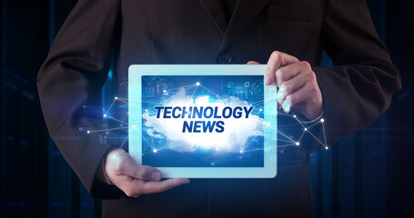 Young business person working on tablet and shows the inscription: TECHNOLOGY NEWS