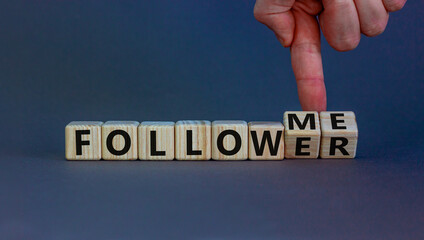 Follow me. Male hand turns wooden cubes and changes the words 'follower' to 'follow me'. Beautiful grey background, copy space. Business concept.