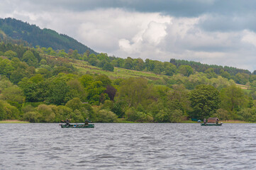 Fototapeta na wymiar Boats with fishermen in Lake of Menteith, Scotland. Concept: Scottish landscapes, Scottisch lakes