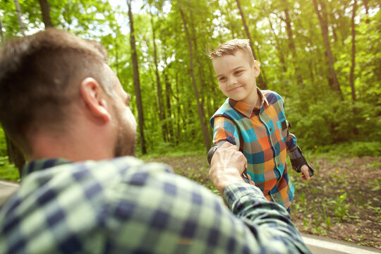 Father and son in the open air, preparing for roller skating. Father's Day.