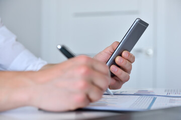 Accountant checks business report on mobile phone.