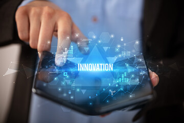 Businessman holding a foldable smartphone with INNOVATION inscription, business concept