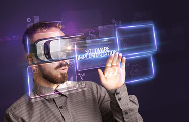 Businessman looking through Virtual Reality glasses with SOFTWARE IMPLEMENTATION inscription, new technology concept