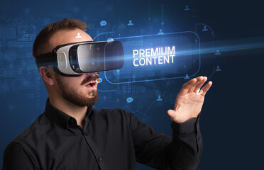 Businessman looking through Virtual Reality glasses with PREMIUM CONTENT inscription, social networking concept