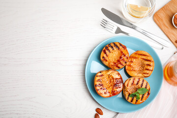 Delicious grilled peaches with honey and mint on white table, flat lay. Space for text