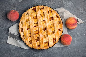 Delicious peach pie and fresh fruits on grey table, flat lay