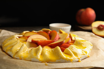 Uncooked peach pie on wooden table, closeup