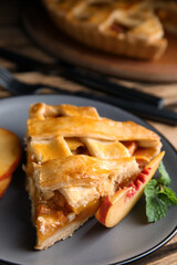 Piece of delicious fresh peach pie served on table, closeup