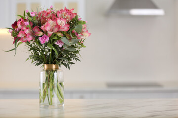 Vase with beautiful alstroemeria flowers on table in kitchen, space for text. Interior design