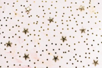 Trendy golden foil confetti stars on pink background. Christmas festive abstract backround. Birthday party, New Year, Christmas celebration, holidays, winter and dreams concept