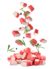 Cut fresh crab sticks, rosemary and allspice falling on white background