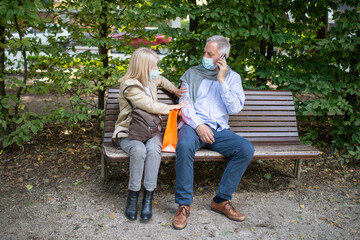 Social distancing and separation concept, coronavirus prevention while sitting on a bench in a park