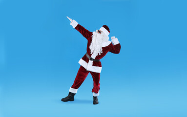 Full length portrait of Santa Claus with sunglasses on light blue background