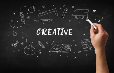 Hand drawing CREATIVE inscription with white chalk on blackboard, education concept