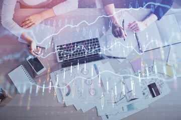 Double exposure of woman hands working on computer and forex graph hologram drawing. Top View. Financial analysis concept.