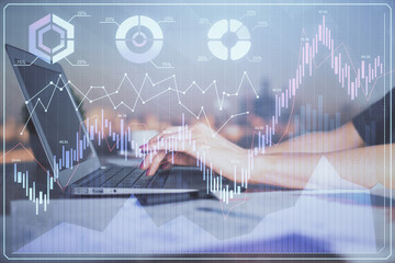 Double exposure of businesswoman hands typing on computer and forex chart hologram drawing....