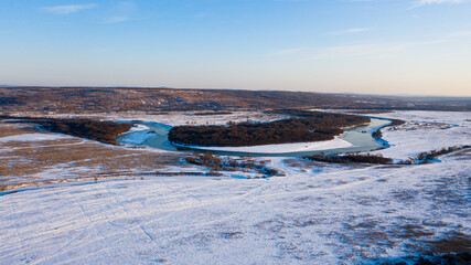 Snowy forest and river photographed from drone