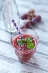 Fresh smoothie in a glass. Bright wooden background. Close up.	