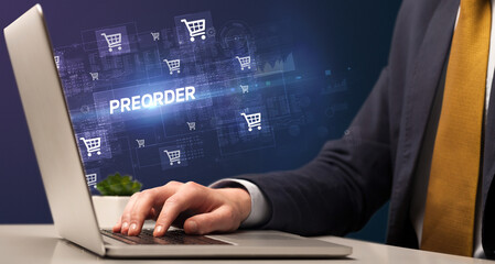 Businessman working on laptop with PREORDER inscription, online shopping concept
