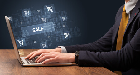 Businessman working on laptop with SALE inscription, online shopping concept