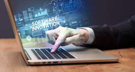 Businessman working on laptop with SOFTWARE INNOVATION inscription, cyber technology concept