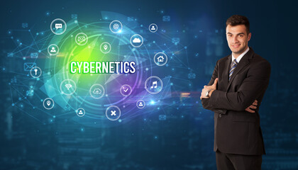 Businessman thinking in front of technology related icons and CYBERNETICS inscription, modern technology concept