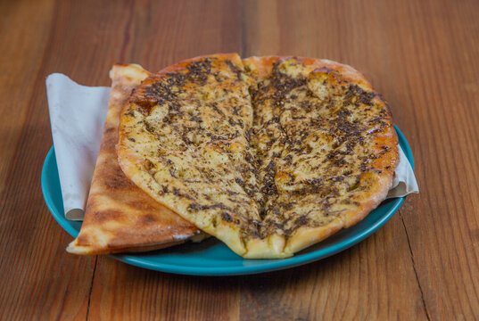Manakish Zaatar | Lebanese Traditional Breakfast Thyme Pastry in plate over natural wood table