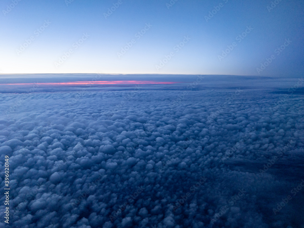 Wall mural aerial view above layer of small puffy altocumulus clouds at break of dawn