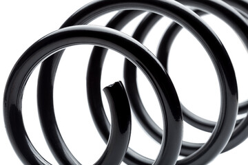 coil spring in black steel car suspension system spare parts, close up replacement part isolated on...