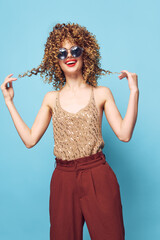Fototapeta premium Beautiful woman Fashion clothes holding on to curly hair smile sunglasses red lips 
