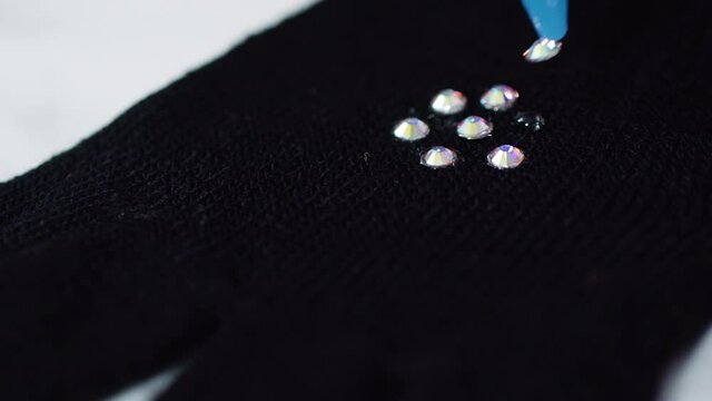 Close up view. Rhinestone gloves with pretty stones into a snowflake pattern.