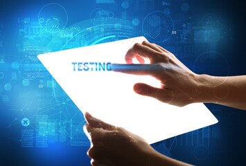 Hand holdig futuristic tablet with TESTING inscription, new technology concept