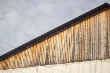 The roof of the building. Plank roof on concrete fittings. Old house. Blank wall. Ridge roof type.