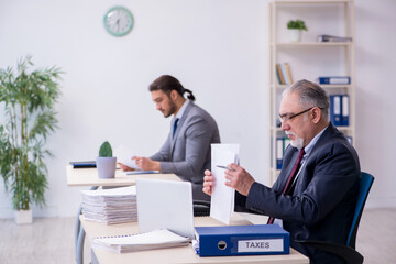 Old boss and his young assistant working in the office