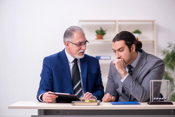Two businessmen and meditation balls on the table