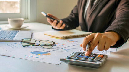 Asian accountants are using calculators to calculate company budgets, financial ideas and financial accounting.