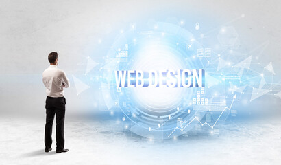 Rear view of a businessman standing in front of WEB DESIGN inscription, modern technology concept