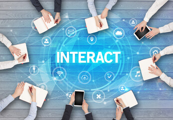 Group of people having a meeting with INTERACT insciption, social networking concept