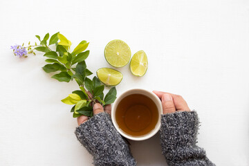 hand of young girl holding cup herbal honey lemon tea healthy drinks health care for sore throat with lemon slice  in winter season decoration on background white wooden