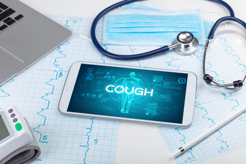 Tablet pc and doctor tools with COUGH inscription, coronavirus concept