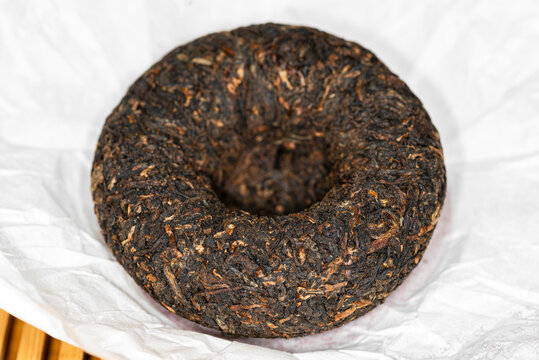 Chinese Cooked Pu Er tea in the form of a nest in a paper wrapper, close-up image. 
