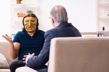 Young man wearing masks during psychotherapy session