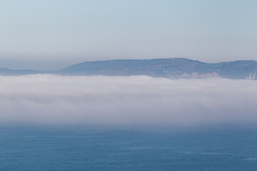 Fototapeta premium fog bank over the sea with mountains