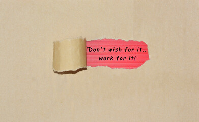 Motivational quote written on brown torn paper